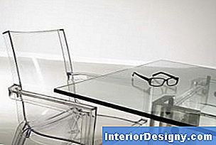 Uma mesa de vidro com cadeiras Lucite e uma elegante base metálica quase desaparece no espaço minimalista ou monocromático.