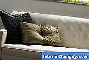 Ein Teppich und ein Tisch vor einer Couch in der Nähe eines Fensters bilden einen sekundären Schwerpunkt.